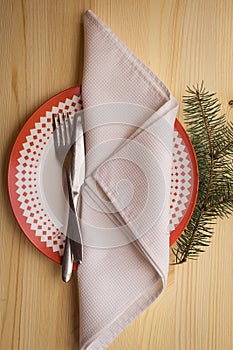 Christmas table place setting with dinner plates, napkin, cutlery, fir