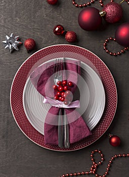 Christmas table place setting with empty gray and red plates, with festive decorations at wood background