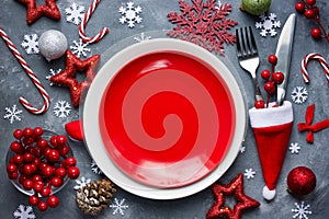 Christmas table place setting with empty red plate, cutlery in s