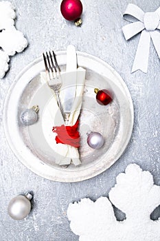 Christmas table place setting. Holidays background. Silver plate, knife and fork with christmas decorations. Top view.