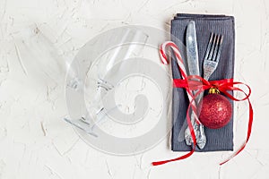 Christmas table place setting with napkin, fork, knife, ball, candy canes, glasses. Christmas holidays background. Flat Lay, Top