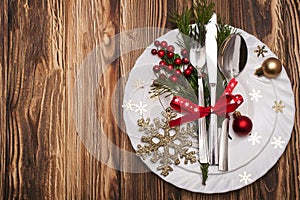 Christmas table place setting with pine branches,ribbon and bow.