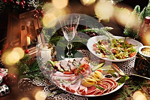 Christmas table with a platter of sliced ham and cured meat and salad