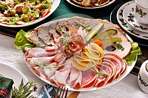 Christmas table with a platter of sliced ham and cured meats