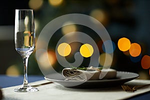 Christmas Table Served with Glass and Napkin with Rosemary Branch of Fir on Plate photo