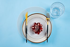 Christmas table setting with modern dishware and decorations on blue background. Top view. New Year place setting