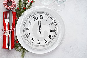 Christmas table setting with plate clock, napkin and cutlery