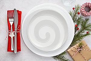 Christmas table setting with plates, red napkin, fork and knife