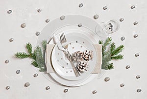 Christmas table setting with silver decorations on gray background. Top view, flat lay. New Year party