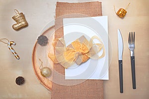 Christmas table setting. wooden plate and silverware on wooden background. Top view