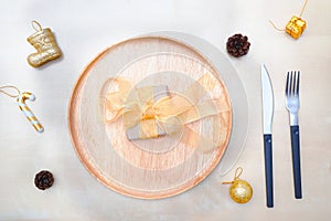 Christmas table setting. wooden plate and silverware on wooden background.