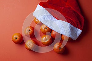 Christmas tangerines in a Santa hat on an orange background, Christmas fruits, festive symbol photo