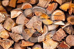 Christmas texture background of dry wooden log cabins. Woodpile of cut Lumber for forestry industry