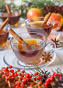 Mulled apple cider with spices: cinnamon sticks, cloves, anise on white table