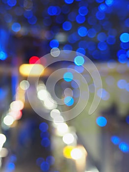 Christmas theme with blue garland. Blurred image of lightst in the dark. Bokeh of streetlights.