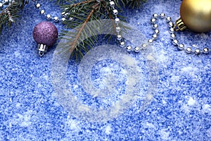 Christmas theme. Christmas decorations, snow and Christmas tree branches lie on a blue background.