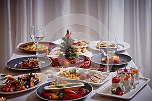 Christmas themed dinner table with a variety of appetizers and salads