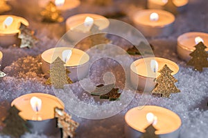 Christmas time candles with golden xmas trees decoration on snow