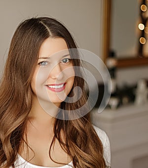 Christmas time and holiday mood concept. Happy smiling woman and decorated xmas tree lights on background