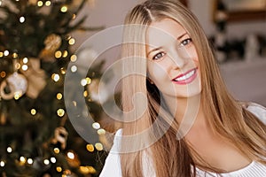 Christmas time and holiday mood concept. Happy smiling woman and decorated xmas tree lights on background