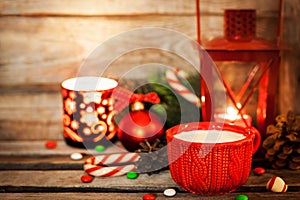 Christmas time red cup of milk and latern with candle light, holiday decorations around