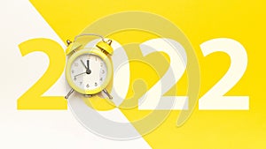 Christmas time 2022. Retro style yellow clock in happy Christmas midnight. Countdown to new year on happy xmas yellow