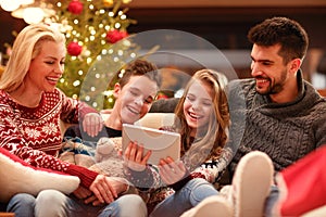 Christmas time- family watching funny video on digital tablet