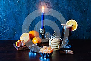 Christmas time, winter, mulled wine in glass, cinnamon, orange and mandarin, cookies and chocolate, a candle in a candlestick