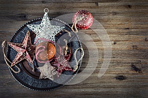 Christmas time. Wrought metal plate filled with various Christmas decorations. Christmas stars, Jingle bells in various positions.