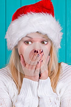 Christmas time. Young woman wearing santa claus hat red dress on blue background