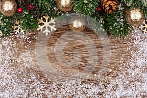 Christmas top border with gold ornaments, branches and snow