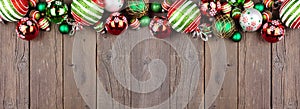 Christmas top border of red, green and white ornaments on a dark wood banner background
