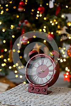 Christmas toy clock on the background of yellow lights of the garland