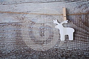 Christmas toy deer hanging over wooden background