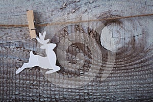 Christmas toy deer hanging over wooden background