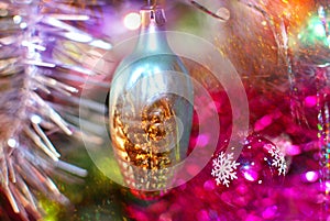 Christmas toy in the form of corn on a background of a bright sparkling multi-colored tinsel