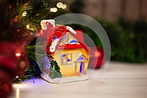 Christmas toy house with a red roof and windows with blue light