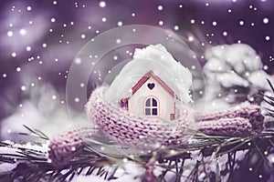 Christmas Toy house is wrapped in a warm scarf, it`s snowing.on