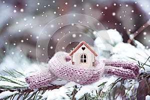 Christmas Toy house is wrapped in a warm scarf, it`s snowing.on photo