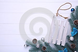 Christmas toy sledge with fir-tree branch on a grey background