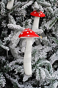 Christmas toys fly agarics hang on Christmas tree in the snow