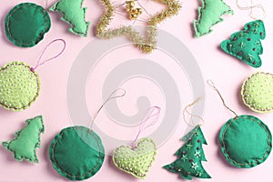 Christmas toys in the form of trees and balls of green color handmade are on a pink background