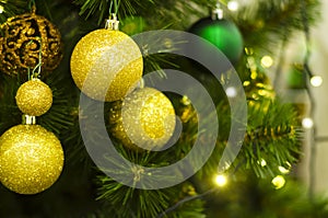 Christmas toys, golden glass balls on a Christmas tree, shiny garland.