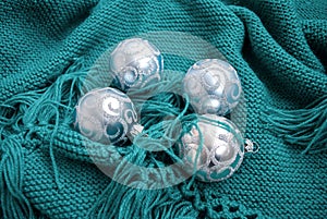 Christmas toys on green knitted blankets. Blue balls newyear decor