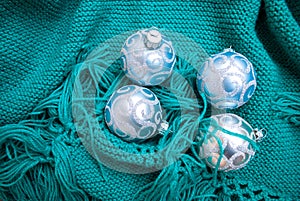 Christmas toys on green knitted blankets. Blue balls newyear decor