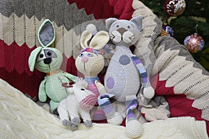 Christmas toys made of wool placed near Christmas tree as Santas gifts, wickerwork