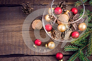 Christmas toys, nuts, fir cones and twigs on a wooden background