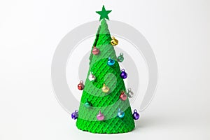 Christmas tree abstract made of ice cream cone and miniature multicolored baubles with star on white