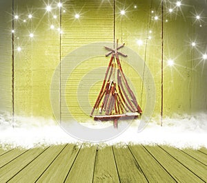 Christmas tree arranged from sticks on empty wooden deck table on sparkly green background. Ready for product display montage