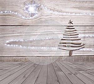 Christmas tree arranged from sticks on empty wooden deck table on sparkly grey background. Ready for product display montage